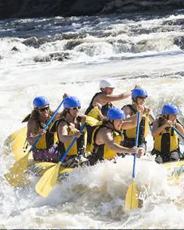 Groupe dans un canot pneumatique sur des rapides d'eau vive