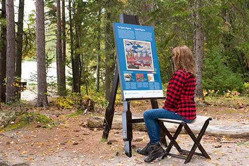 三脚の絵の前に座っている女性