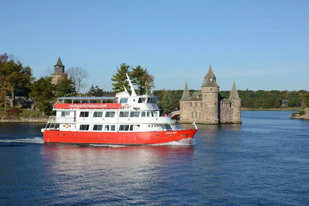 Barco de crucero en un lago que pasa frente a un castillo en una isla