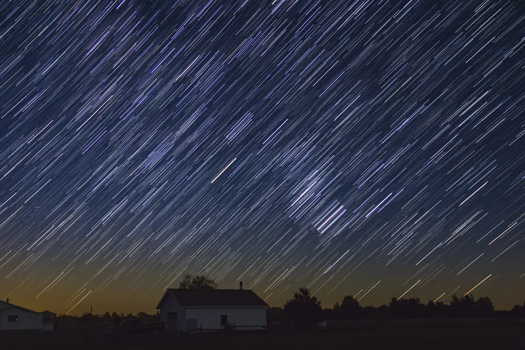 星の劇的なショーは、田舎の農場のシーンの暗い空を照らします
