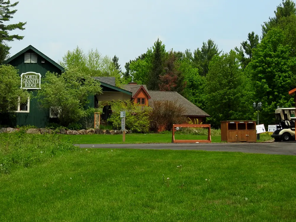 Des pelouses vertes bien entretenues et une forêt entourent le pavillon de golf principal