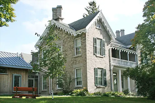 The St.Mary's Museum building sits in the background surrounded by trees and grass.