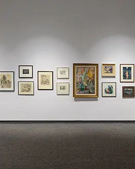 Des œuvres d'art de différentes tailles dans des cadres uniques sont alignées sur un mur de la galerie d'art Tom Thompson.