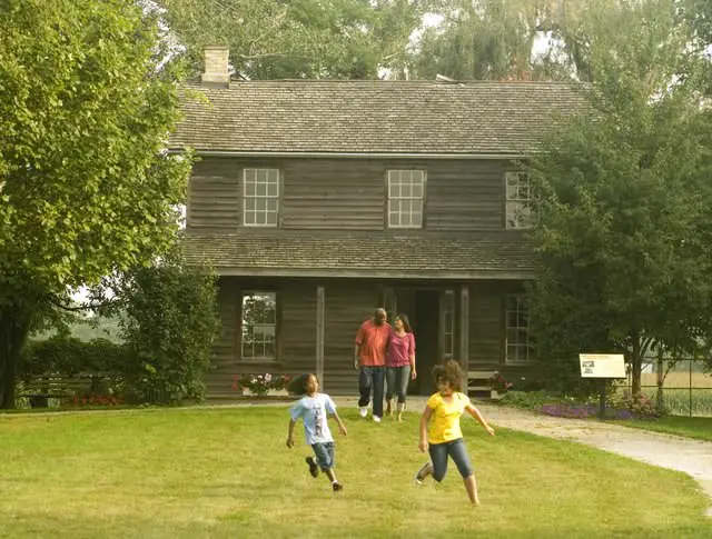 Two adults and two children playing in front of a historic building