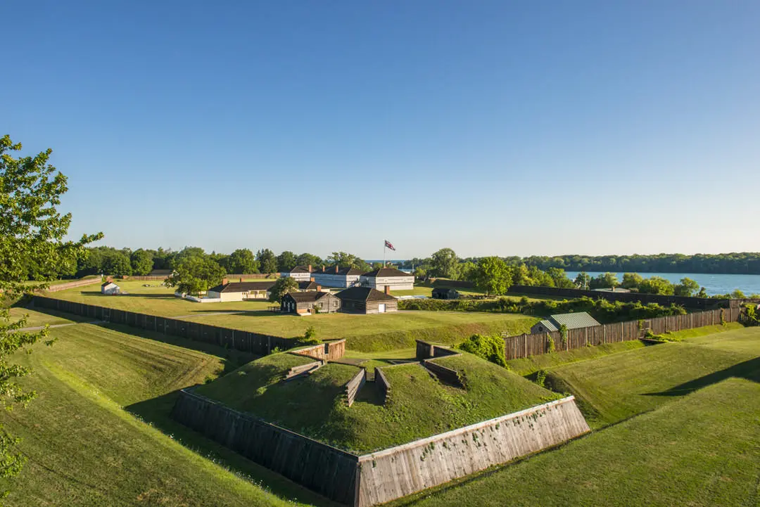 Northfacing view of lawn and buildings of Fort George with Niagara River beyond