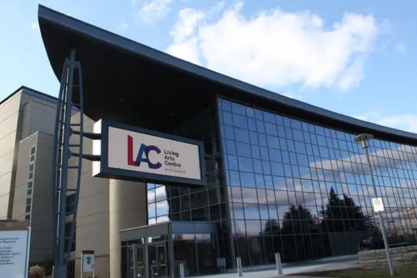 Edificio de varios pisos que muestra paredes frontales y laterales hechas completamente de paneles de vidrio con entrada de vidrio en la parte inferior izquierda