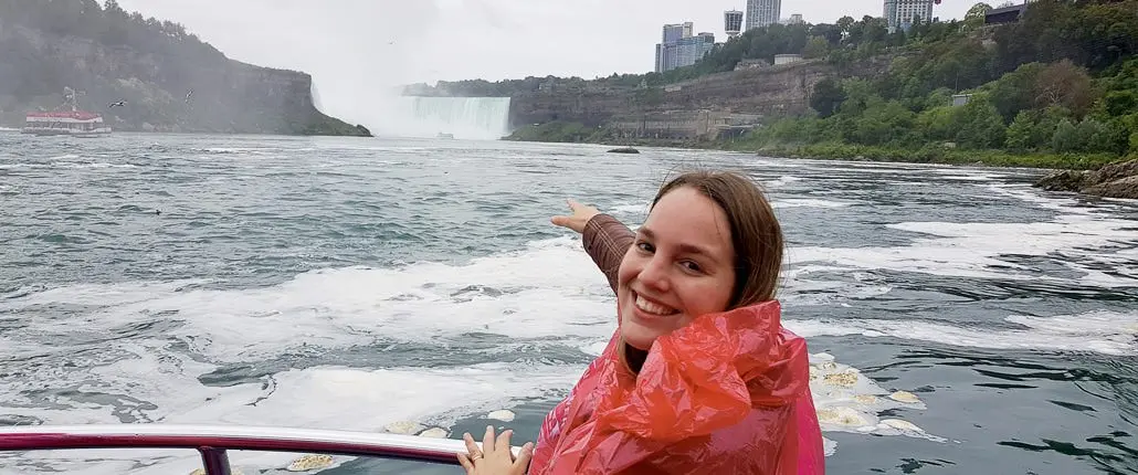 ナイアガラの滝の風景を指すボートに乗った少女