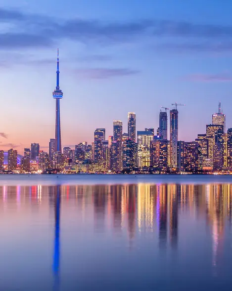 La silhouette de Toronto le soir réfléchie sur une étendue d’eau