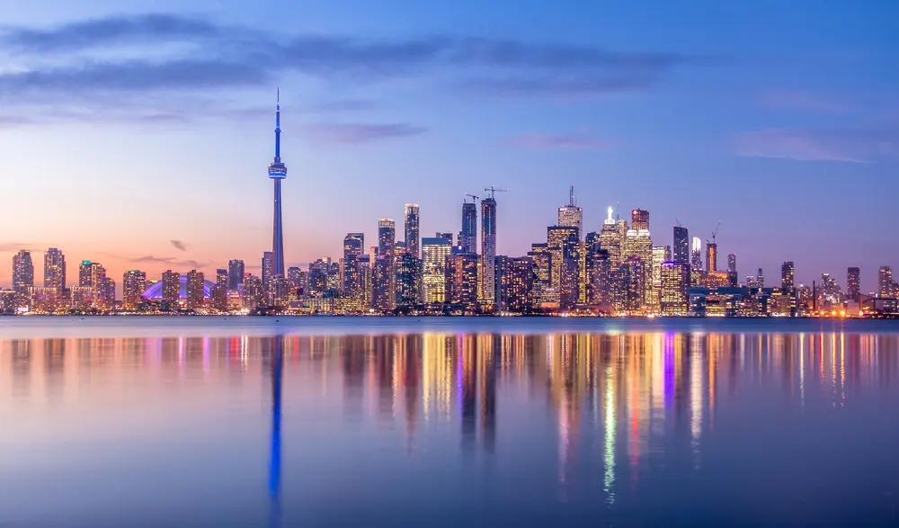 El horizonte de Toronto por la noche se refleja en un cuerpo de agua