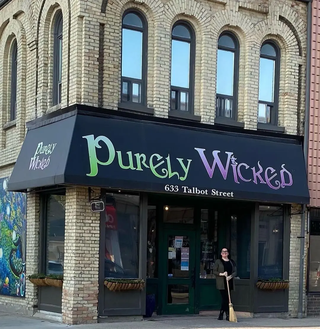 Une femme debout devant une boutique.