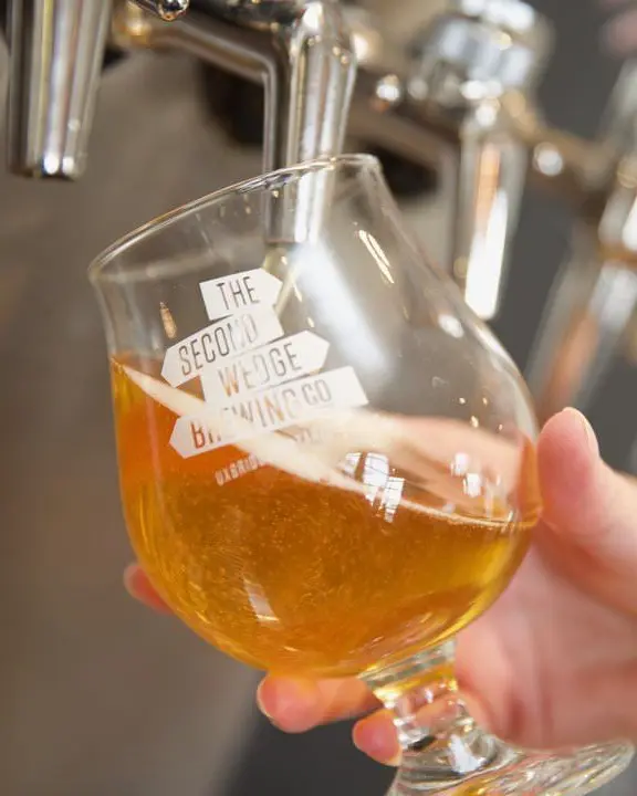 A glass of beer being poured from a beer tap