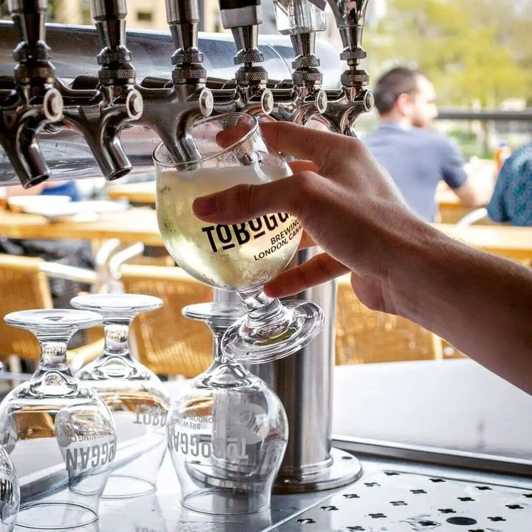 A glass of beer being poured from a beer tap