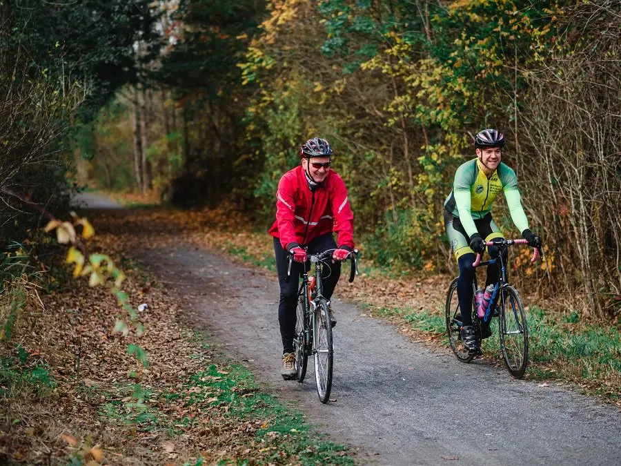 笑顔でトレイルをサイクリングする2人の男性