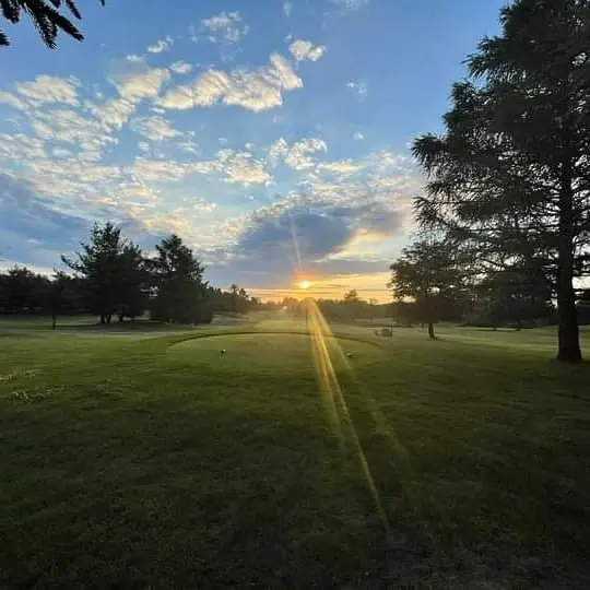 Ciel bleu alors que le soleil se lève sur le terrain de golf