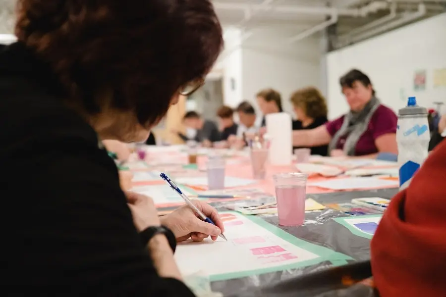 Un grupo de personas pintando en una mesa.