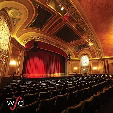 Blick auf ein leeres Auditorium mit wunderschön geschmückter Bühne und Decke