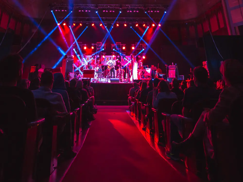 Vue d'une allée avec des sièges des deux côtés à la tête d'un groupe sur scène.