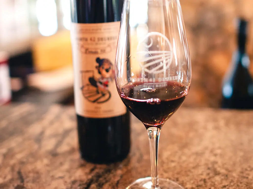 Une bouteille et un verre de vin rouge sont assis sur un comptoir