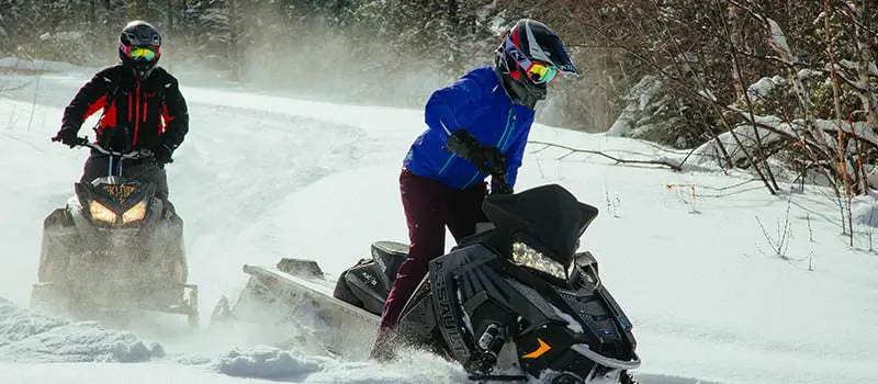 2 motos de nieve viajan en la nieve