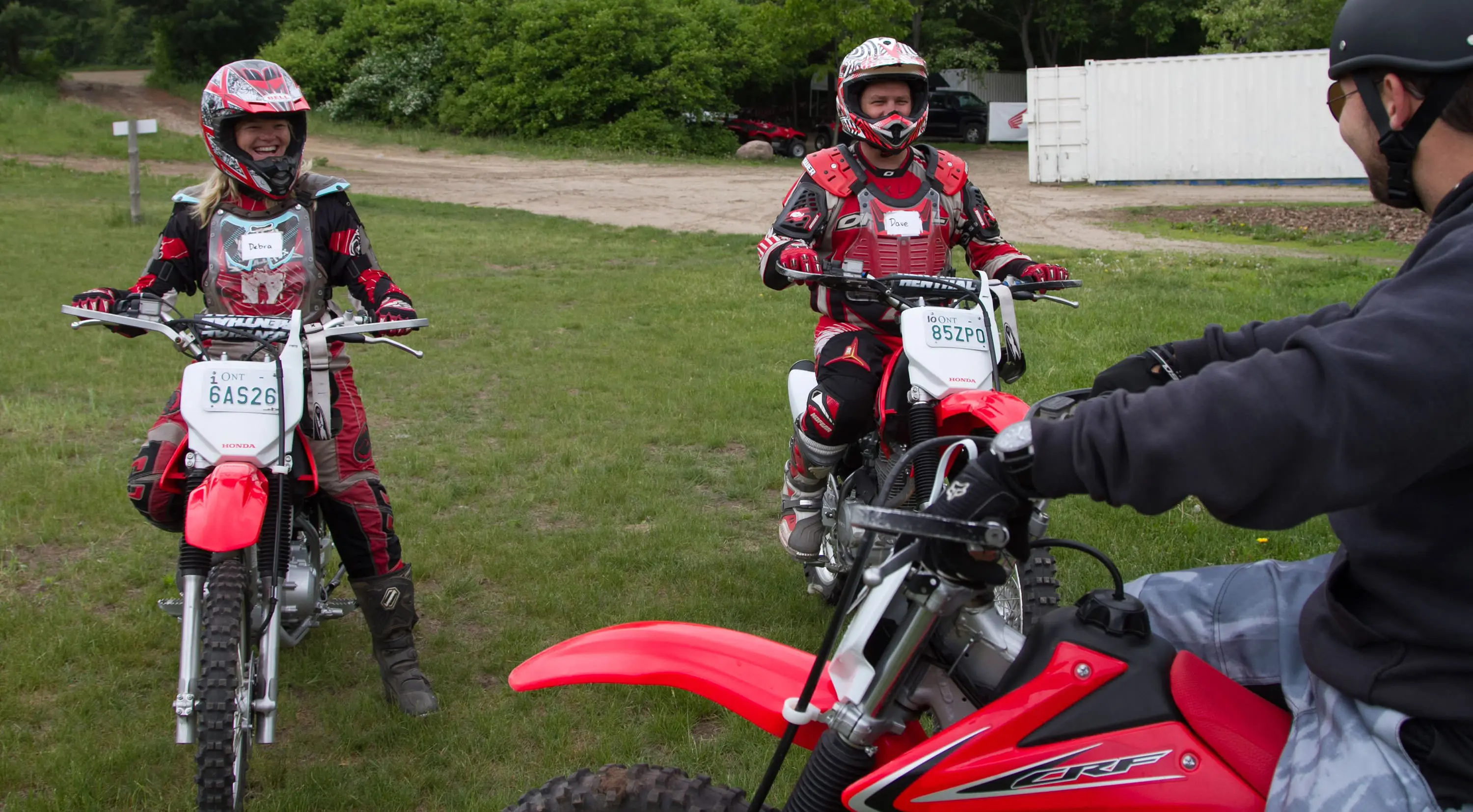 ダートバイクに乗った3人が笑顔で乗る準備をしている