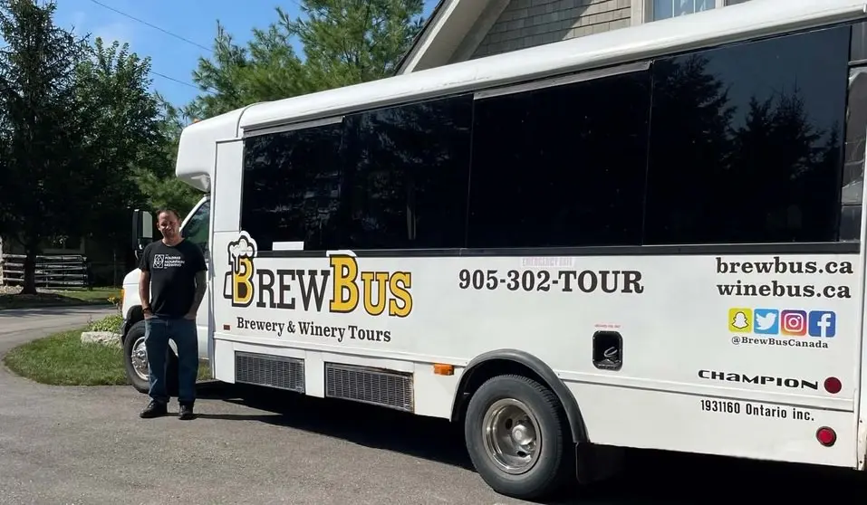 A man standing beside a tour bus