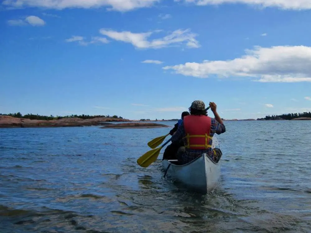 Two people in a canoe paddling towards the lakeshore