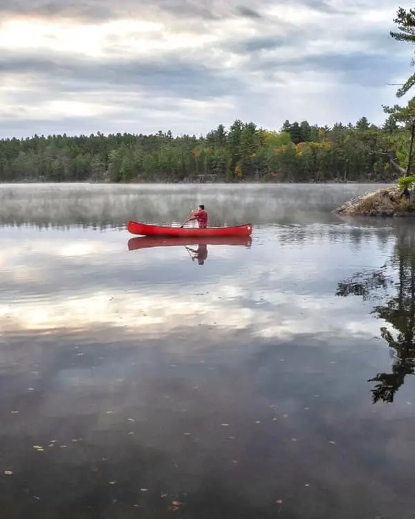 A man paddling on a canoe on the lake