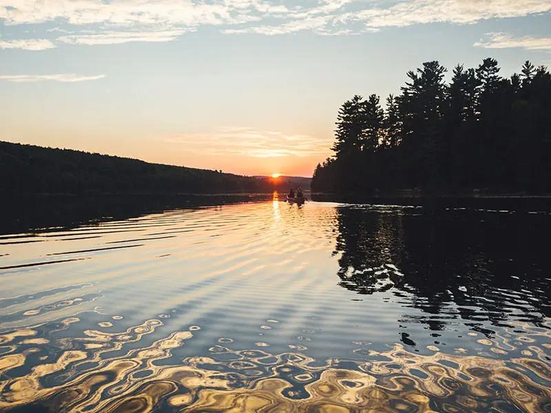 2 people in a boat fishing in the early hours of the morning