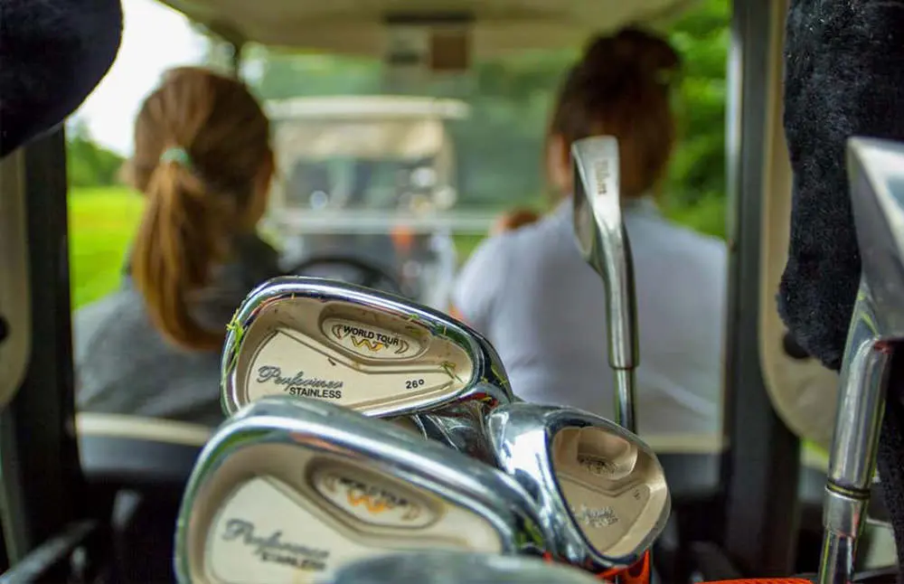 Two woman drive a golf cart across an Ontario golf course.