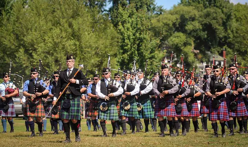 a group of men playing bagpipes in a parade