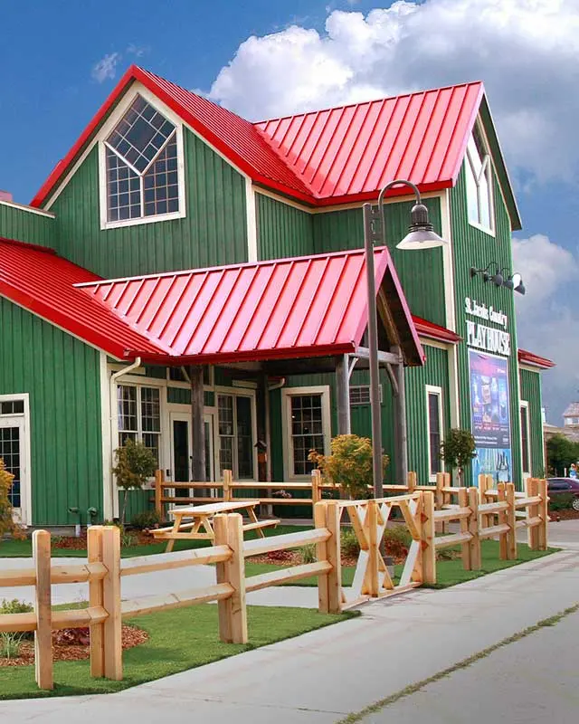 A sculpture and a picnic table in front of a large theatre