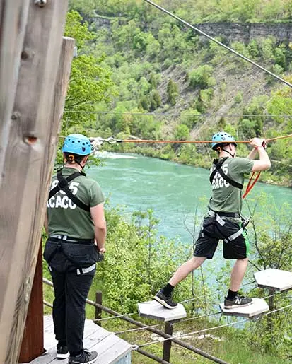 Une personne marchant sur des plates-formes suspendues entre deux cimes d'arbres