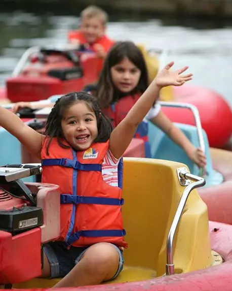 Enfants qui s’amusent en se promenant dans de petits bateaux sur l’eau.