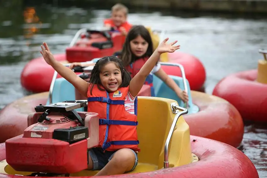 Enfants qui s’amusent en se promenant dans de petits bateaux sur l’eau.