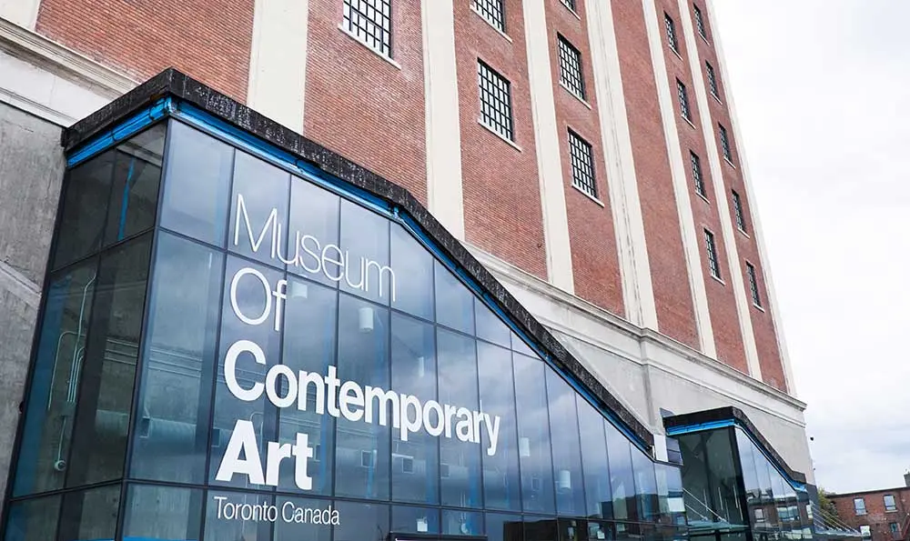 Ein hohes braunes Gebäude mit einem Eingang aus Glas