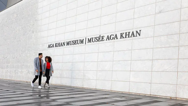 Ein Paar geht vor dem Eingang des Aga Khan Museums spazieren.