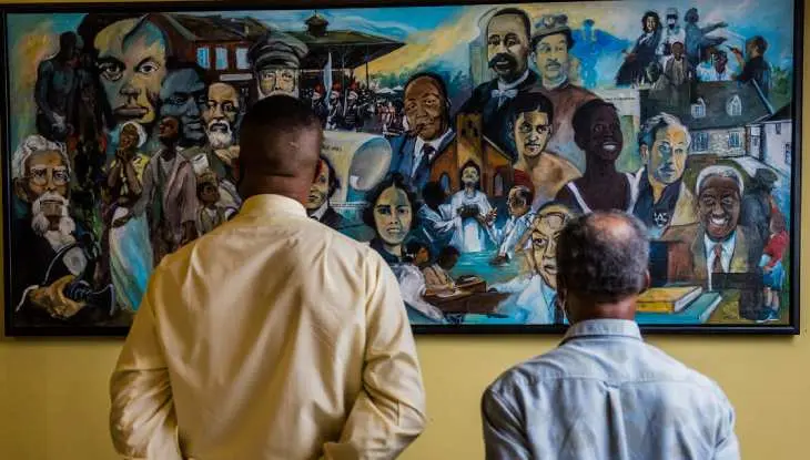 二人の男性が壁画の絵について考えている