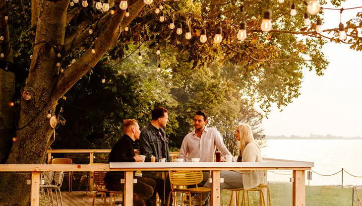 4人の友人グループが屋外のパティオに集まります。