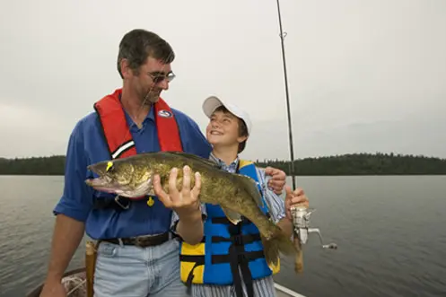 A man and a boy admiring a fish