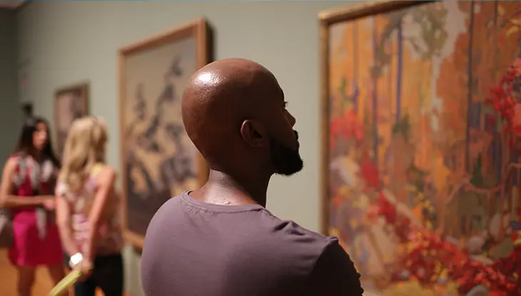 Gente admirando el arte en una pared de una galería.