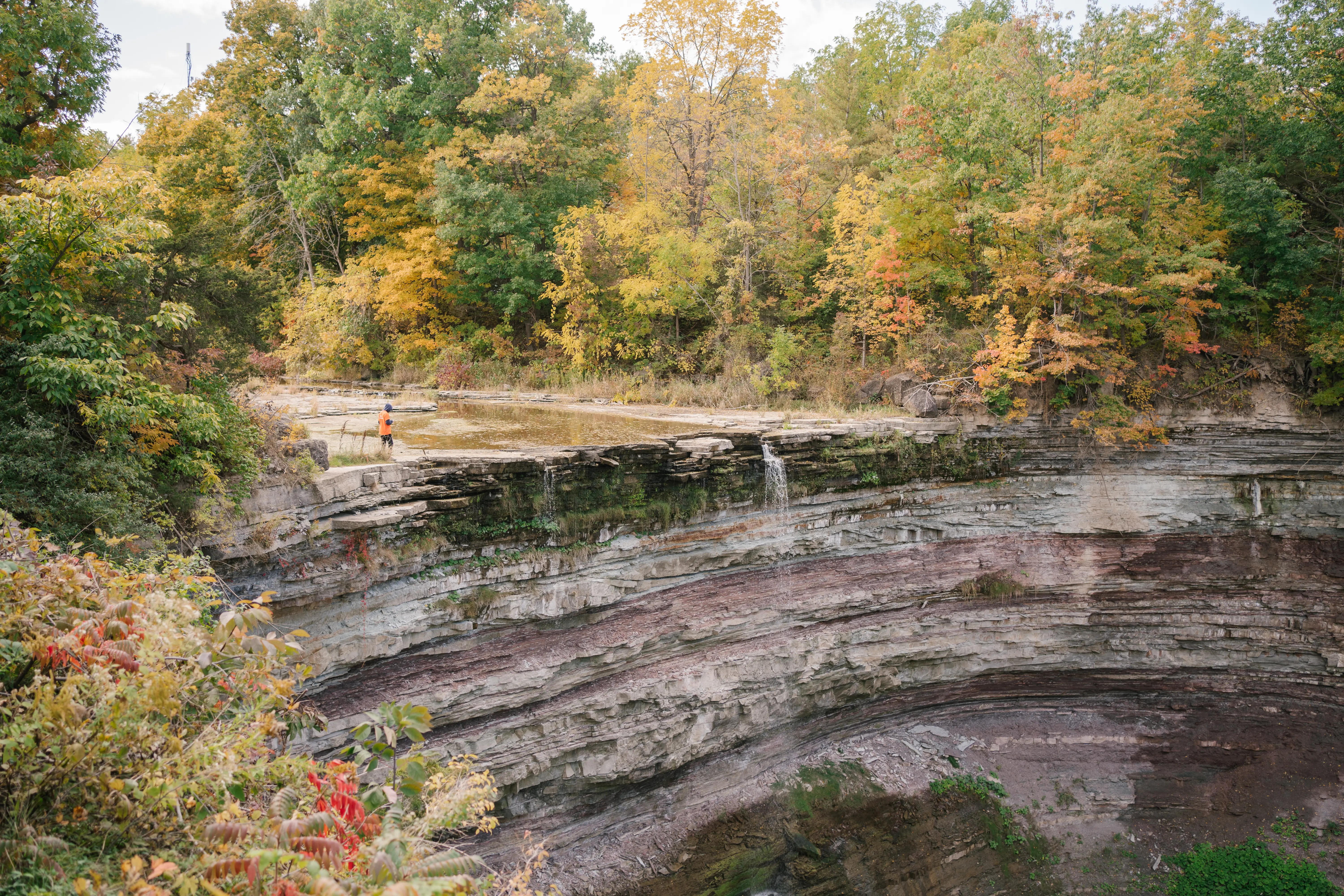 小さな滝のある湾曲した岩の崖