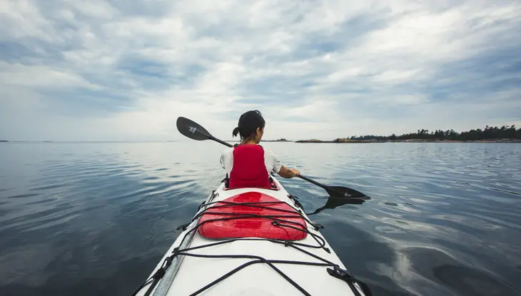 ジョージアン湾の美しく穏やかな海でカヤックを一人で楽しむ女性。