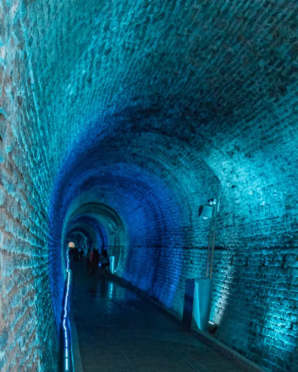 La luz azul ilumina un túnel de piedra.