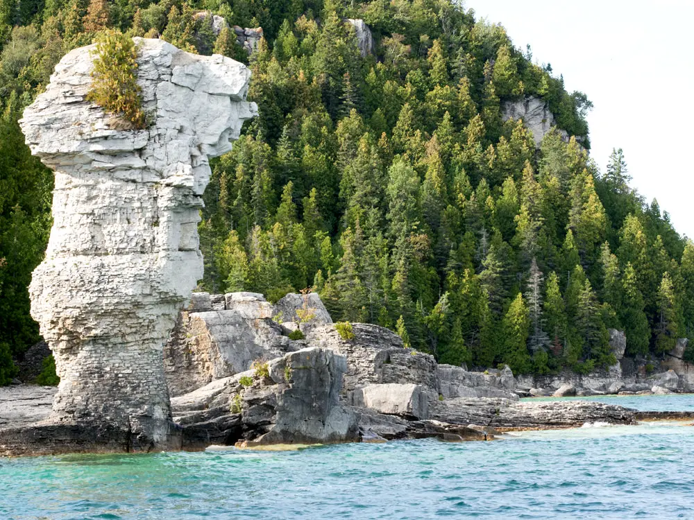 Une formation rocheuse calcaire empilée s'élève des eaux bleues de la baie Georgienne
