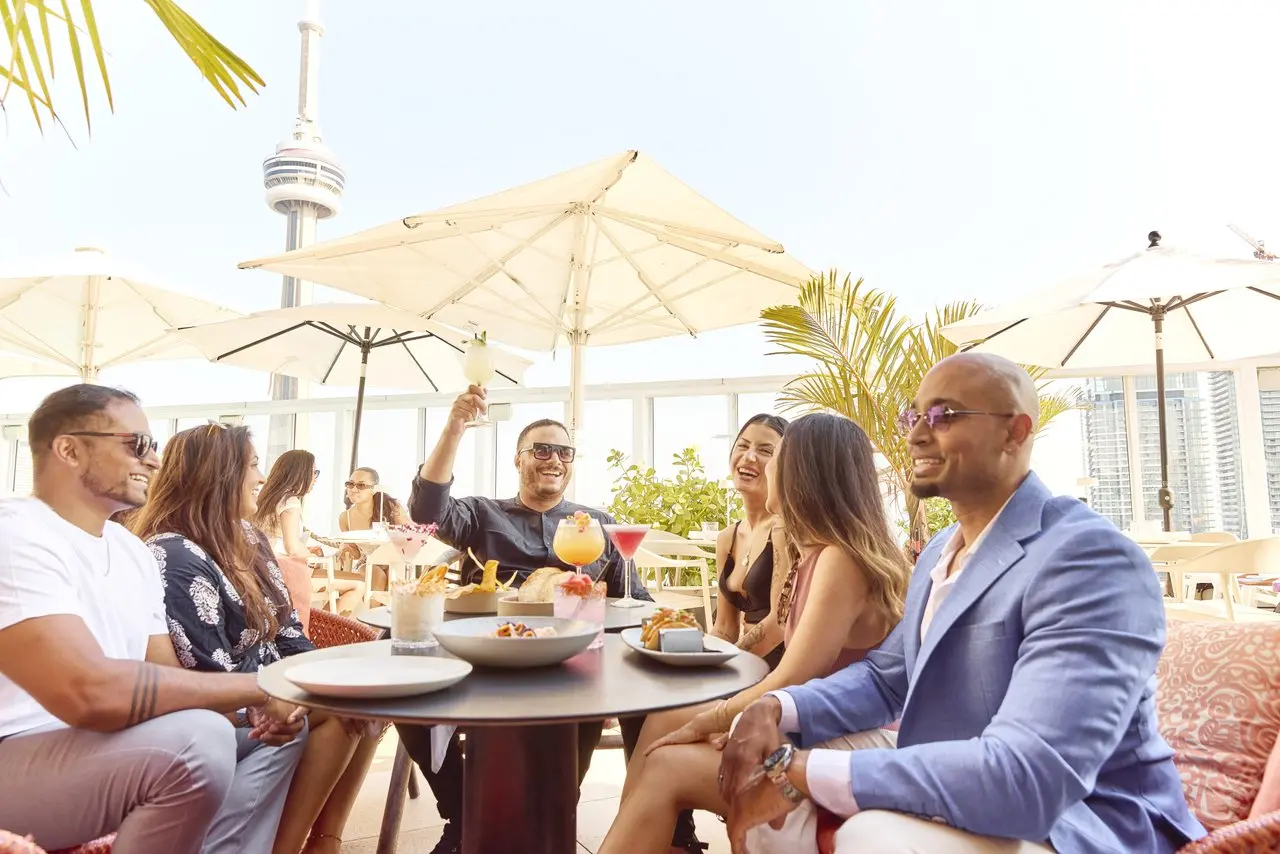 友人のグループがテーブルに座って飲み物と軽食を楽しんでいます。