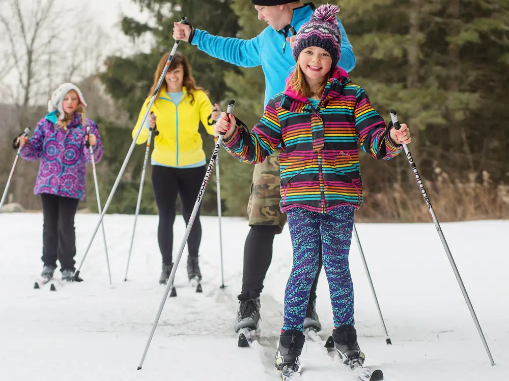 A family of four cross-country skiing at Albion Hills Conservation Area near Caledon.