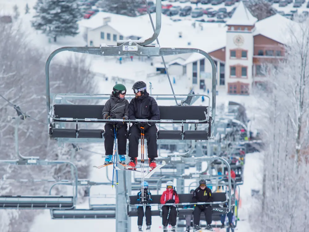Several skiers riding the ski lift at Mount St. Louis Moonstone ski resort.