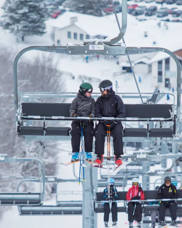 Several skiers riding the ski lift at Mount St. Louis Moonstone ski resort.