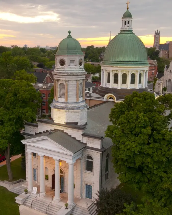 Luftaufnahme eines Gebäudes mit grüner Kuppel in einem Wohnviertel.