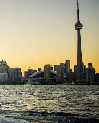 夕暮れ時にボートタクシーがトロントのハーバーフロントへ向かいます。